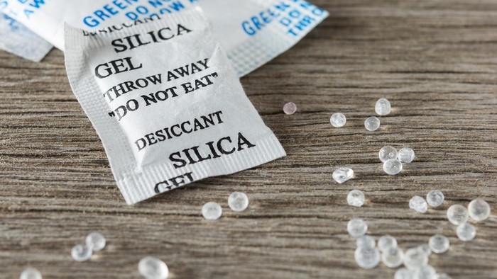 Desiccant silica gel on wooden background