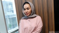 Ia tampak mengenakan kerudung abu-abu, dress kemeja pink, celana dan sepatu khaki. Pool/Palevi S/detikFoto.