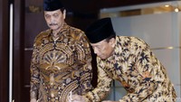 Keduanya kompak mengenakan baju batik bernuansa cokelat.