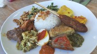 Nasi campur Bali dengan lauk ayam sisit, sate lilit, urap dan telor pindang selalu bikin kangen karena gurih pedasnya.Foto: iStock
