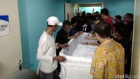 Para kerabat memindahkan jenazah Mike Mohede ke dalam peti.