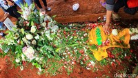 Taburan bunga di kuburan Mike Mohede adapula kaus kuning bertuliskan namanya. Pool/Hanif Hawari/detikFoto.