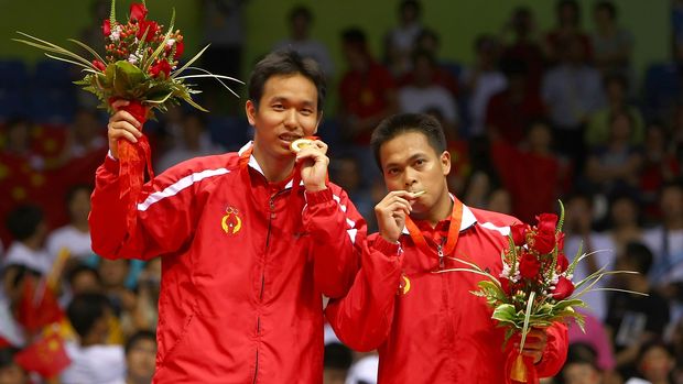 BEIJING - AUGUST 16:  Hendra Setiawan (L) and Markis Kido of Indonesia bite their gold medals in the men's doubles badminton gold medal match at the Beijing University of Technology Gymnasium on Day 8 of the Beijing 2008 Olympic Games on August 16, 2008 in Beijing, China.  (Photo by Lars Baron/Getty Images)