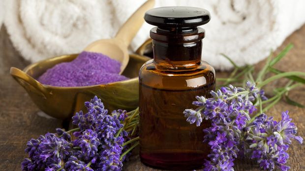 Lavender flowers, apothecary bottle, bowl of bath salt and towels