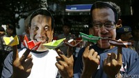 Dua orang nelayan menunjukkan perahu kertas bertuliskan tuntutan, seperti selamatkan teluk Jakarta dan selamatkan nelayan Jakarta.