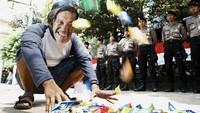 Puluhan perahu kertas diletakkan di depan polisi yang berjaga di Kemenko Kemaritiman.