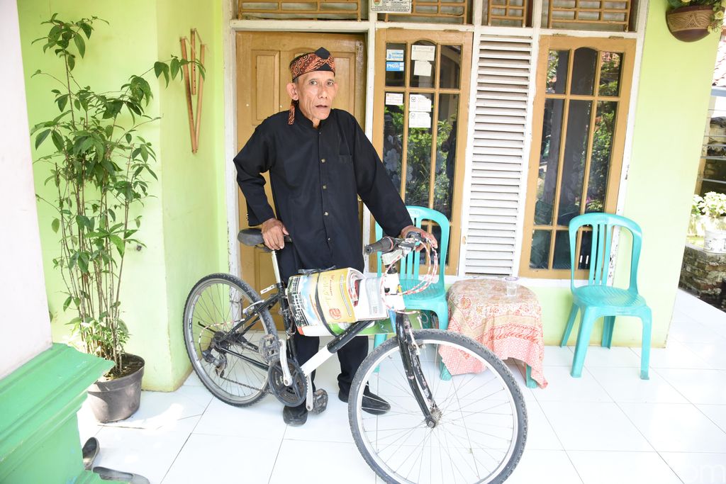 Abah Uju dan sepeda yang dipakai berkeliling untuk membawa buku "