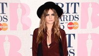 Di acara BRIT Awards 2015, ia tampak santai dengan blus kemeja marun polka dot dipadu rompi, celana, heels, dan topi hitam. Ian Gavan/Getty Images/detikFoto.