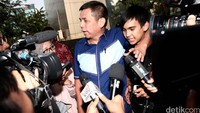 Mengenakan kemeja berwarna biru, ia terlihat keluar dari samping gedung.
