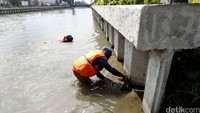 Petugas Dinas Kebersihan Kota Bekasi membersihkan endapan lumpur di Kalimalang.