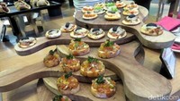 Mini Bruschetta yang disusun bertingkat dengan topping jamur serta truffle oil, sayur dan keju serta siraman potongan tomat dan paprika.