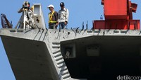 Para pekerja menyelesaikan proyek jalan layang.