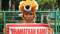 3 Orang pendemo mengenakan kostum binatang.