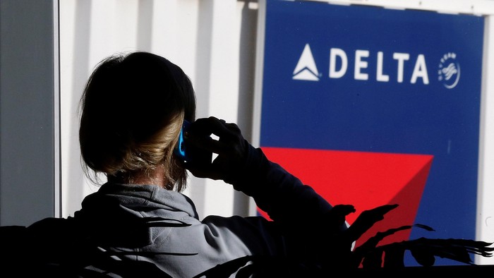 FILE PHOTO - A passenger talks on her phone at a Delta Airlines gate a day before the annual Thanksgiving Day holiday at the Salt Lake City international airport, in Salt Lake City, Utah November 21, 2012. REUTERS/George Frey/File Photo