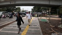 Warga melintas di trotoar percontohan di Jalan Jati Baru, Tanah Abang, Jakarta Pusat, Senin (8/8).