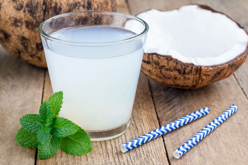 coconut water and fresh coconut on wooden background