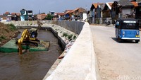 Alat berat mengeruk lumpur di Sungai Ciliwung.