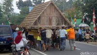 Bagian rumah yang sudah dibongkar dan hanya menyisakan atap utama rumah tersebut kemudian dibawa oleh sekitar 25 warga dari Desa Wangon menuju Desa Randegan atau sekitar 5 kilometer dengan berjalan kaki melalui jalan utama Banyumas-Cilacap.