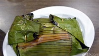 Kepiting asap ini disajikan dengan dibungkus daun pisang. Kepiting yang dipakai menggunakan jenis yang besar dengan bobot mencapai 1 Kg per ekornya (Khafifah/detikTravel)