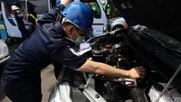 Petugas Dinas Perhubungan mengecek mesin kendaraan.