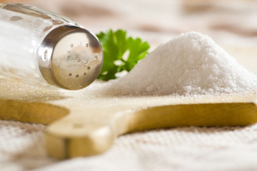 Sea salt on cloth and wooden plate in kitchen.