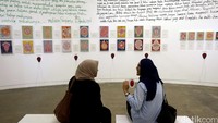 Dua Orang Pengunjung berbincang sambil menyaksikan puisi-puisi yang dipamerkan.  