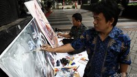 Seorang pelukis membuat sebuah lukisan dengan karakter utama Hanoman.