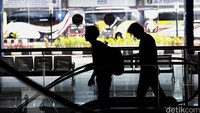Dua Orang pengunjung sedang menuruni eskalator di Terminal Terpadu Pulogebang.