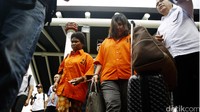 Para tersangka tampak mengenakan baju tahanan berwarna oranye.