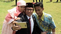 Seorang bapak berfoto bersama kedua anaknya.