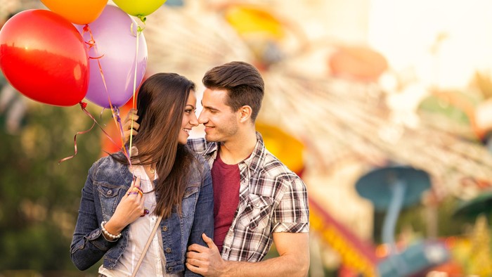 laughing couple in bumper car enjoyment in attraction - shoot with lens baby