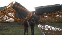 Petugas berusaha mengevakuasi gorbong yang jatuh ke sungai. Cristobal Saavedra/Reuters.