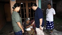 Sudirman menyalami seorang nenek yang sedang memangku cucunya.