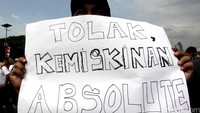 Seorang sopir membentangkan poster tuntutan.