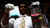 Polisi menunjukan narkoba dengan jenis ekstasi dan bungkus makanan kucing yang berhasil diamankan.