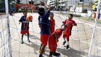Lapangan futsal ini menjadi arena bermain bola bagi anak-anak.
