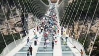 Jembatan gantung dengan lantai kaca terpanjang di dunia akhirnya buka di Hunan, China. Jembatan ini berada di Zhangjiajie Grand Canyon. Baru resmi dibuka, langsung banyak yang datang ke sana (AFP)