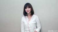 Ia tampak mengenakan kemeja putih dengan ripped jeans serta heels berwarna pink, senada dengan tas yang dikenakannya. Pool/Gus Mun/detikFoto.