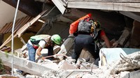 Tim penyelamat mencari korban gempa di reruntuhan bangunan. Ciro De Luca/Reuters/detikFoto.