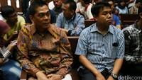Sanusi tampak mengenakan batik dan menunggu di deretan kursi pengunjung.