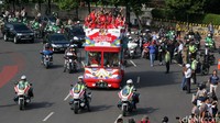 Tampak puluhan mobil dan sepeda motor mengiringi rombongan atlet.