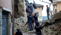 Polisi mengevakuasi warga yang terjebak di lantai atas sebuah gedung di Amatrice. REUTERS/Remo Casilli.