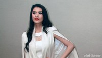 Ibu satu anak itu tampil dengan cape dan celana panjang putih serta heels berwarna pink. Pool/Gus Mun/detikFoto.