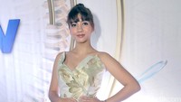 Pesinetron itu tampil dengan gaun hijau putih bermotif floral berwarna emas yang dipadukan dengan heels putih. Pool/Noel/detikFoto.