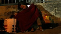 Seorang ibu menyelimuti anaknya agar dapat tidur. REUTERS/Stefano Rellandini.