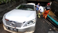 Petugas mengevakuasi mobil-mobil yang terendam di basement Kemang Square.