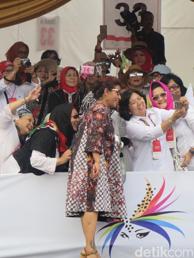 Dalam aksinya, Susi berjalan dari panggung utama menuju bibir catwalk di mana ratusan fotografer telah menantinya. Sambil menebar senyum terbaiknya, ia melambaikan tangan menyapa ribuan penonton di sisi kiri dan kanan. (Foto: Daniel Ngantung/Wolipop)