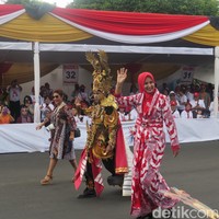 Begini aksi Menteri Susi berjalan di jalanan Alun-alun Kota Jember yang disulap menjadi landasan peraga JFC 2016. Didampingi presiden dan penggagas JFC, Dynand Fariz, serta Bupati Jember Faida, perempuan 53 tahun itu muncul dalam balutan dress batik selutut yang mengekspos tato di kaki kanannya. (Foto: Daniel Ngantung/Wolipop)