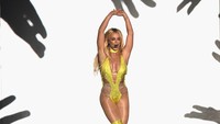Britney tampil seksi dengan jumpsuit kuning semi transparan dengan sequin. Michael Loccisano/Getty Images/detikFoto.