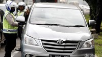 Polisi menilang pengendara yang memakai pelat nomor ganjil di Bundaran Senayan, Jakarta, Selasa (30/8/2016).